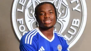 West Ham transfer target Abdul Fatawu pictured in front of the Leicester City crest.